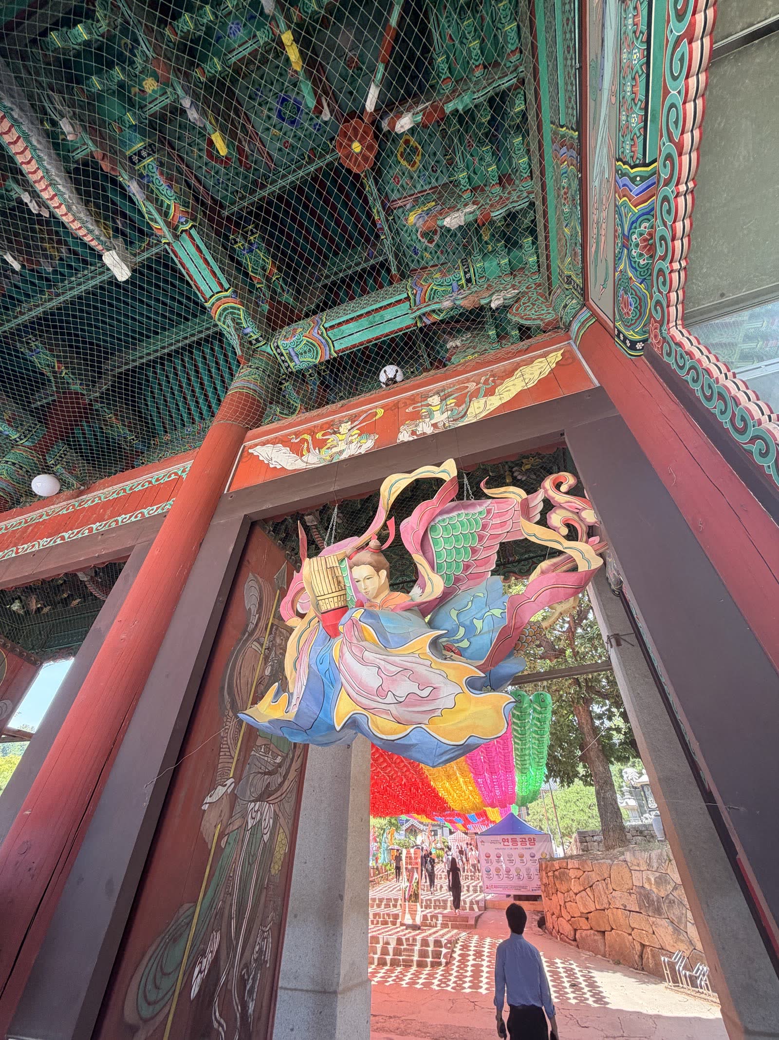 從門樓內望向參道，可見丹青彩繪天花板與掛飾，遠處蓮燈成列