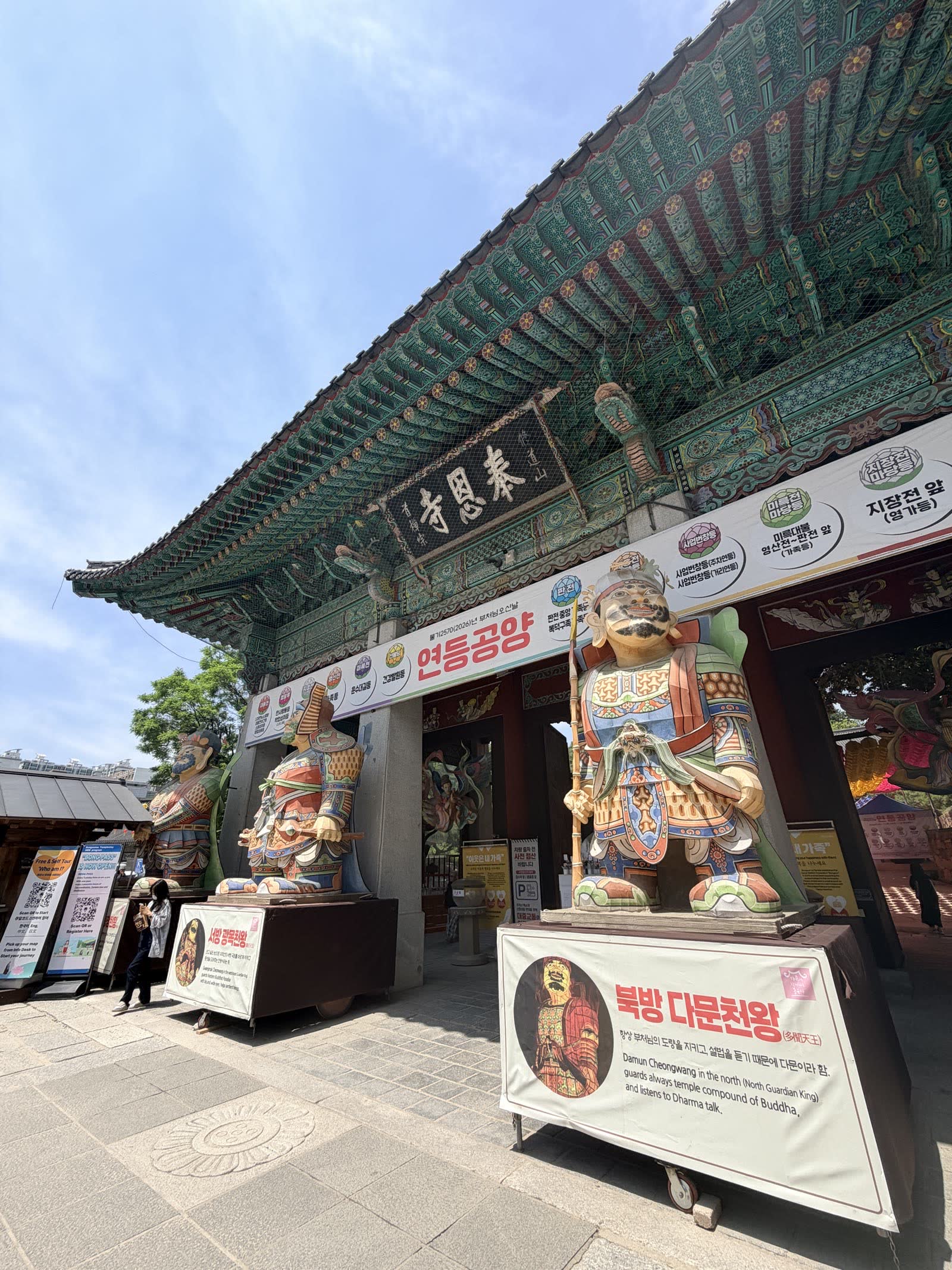 奉恩寺山門匾額與北方多聞天王像，底座有中英解說牌