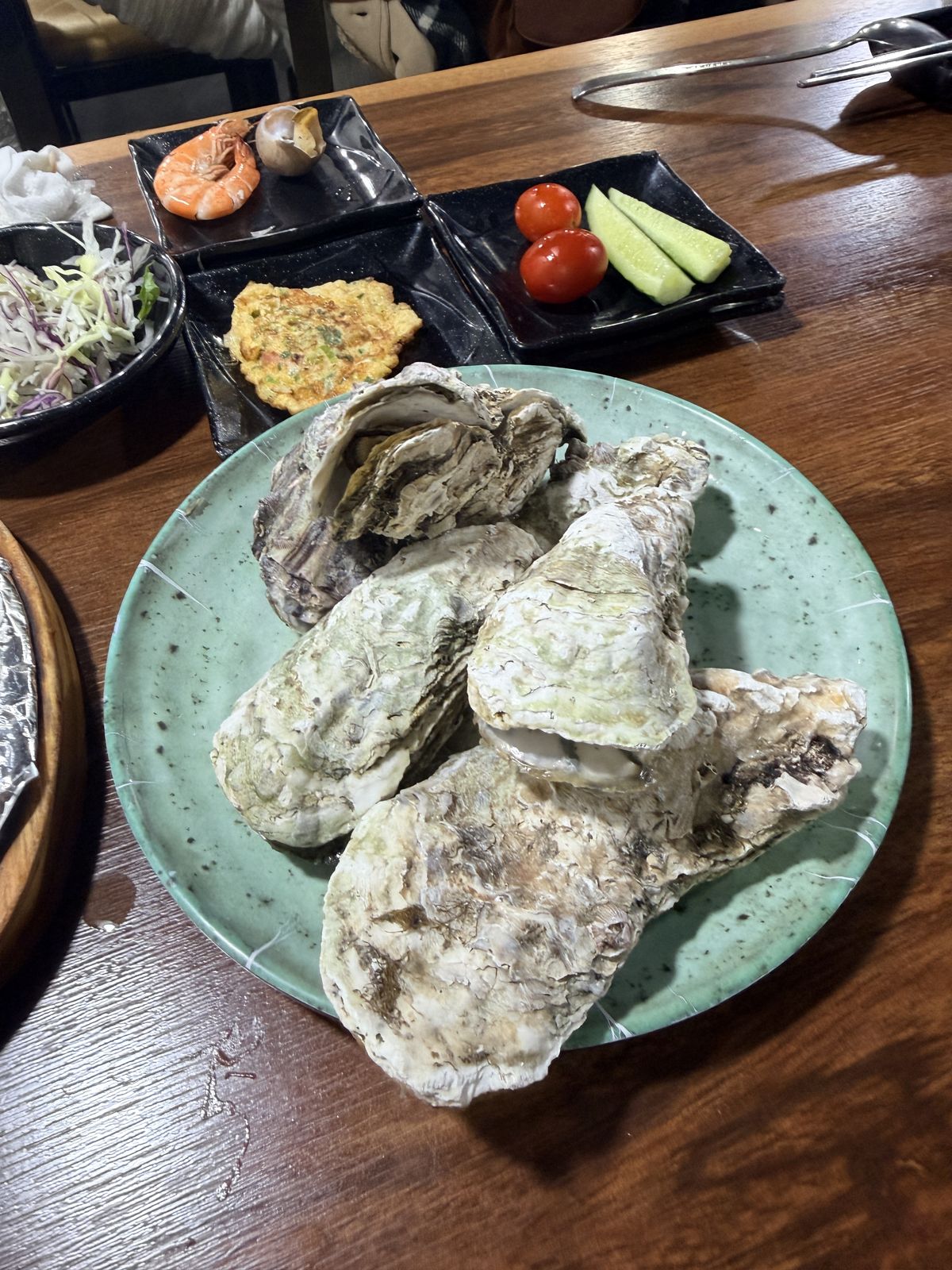門口透明圓管水族箱內活跳的오도리車蝦,橘紅條紋清晰