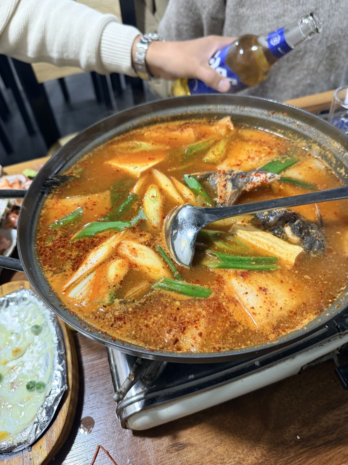 紅湯海鮮辣鍋매운탕,內有魚塊、蔥段、白蘿蔔與豆腐