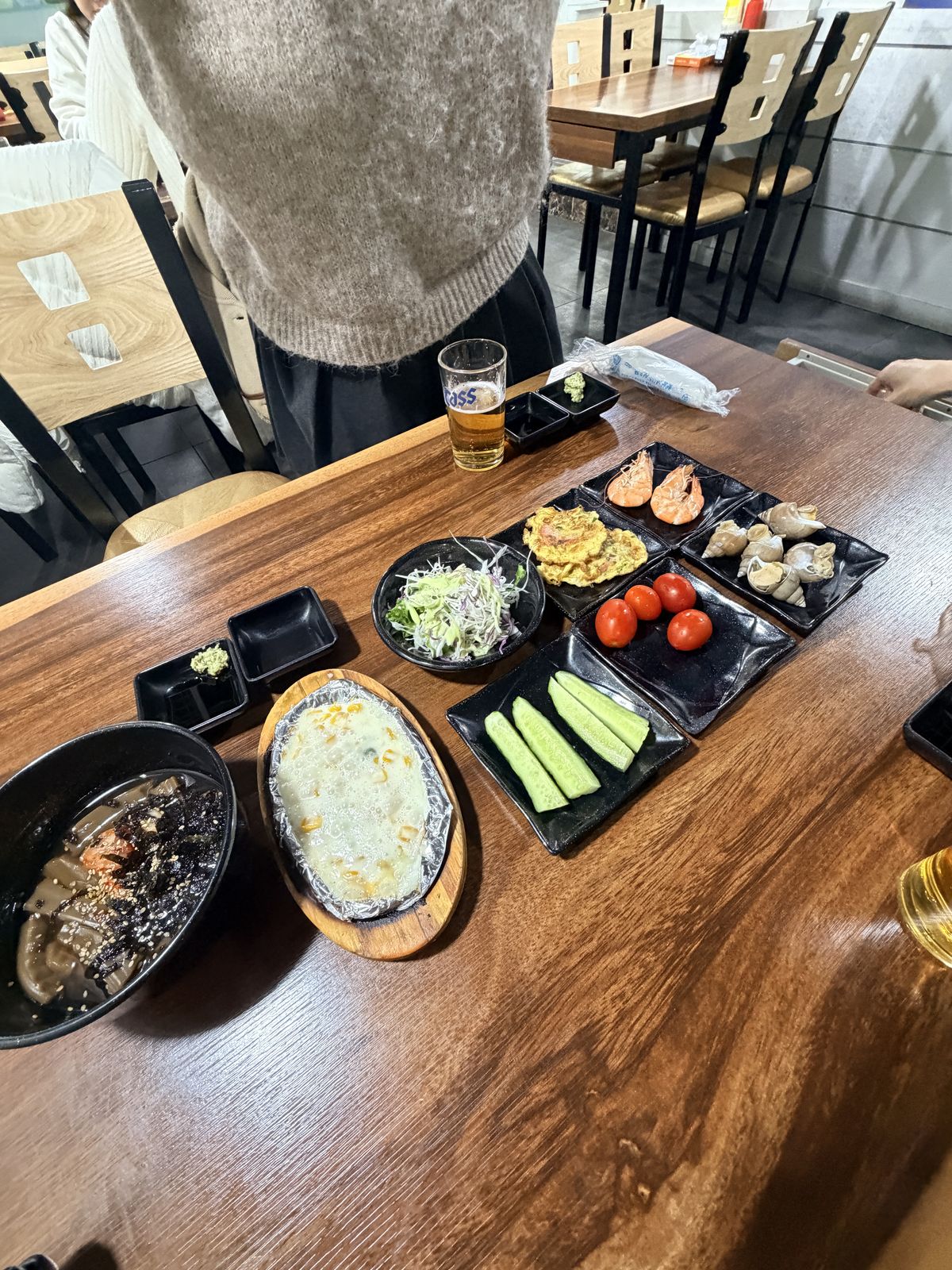 活蝦店整桌擺盤,附番茄、小黃瓜、高麗菜絲、炸物與玉米起司等小菜