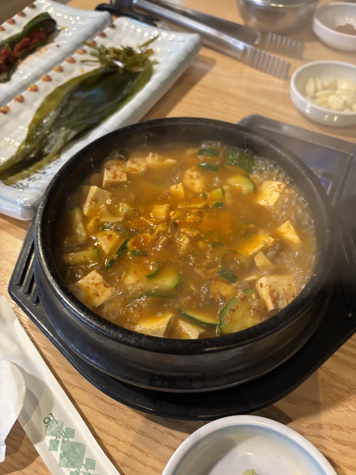 石鍋大醬湯特寫,豆腐與櫛瓜在濃稠湯頭中滾燙