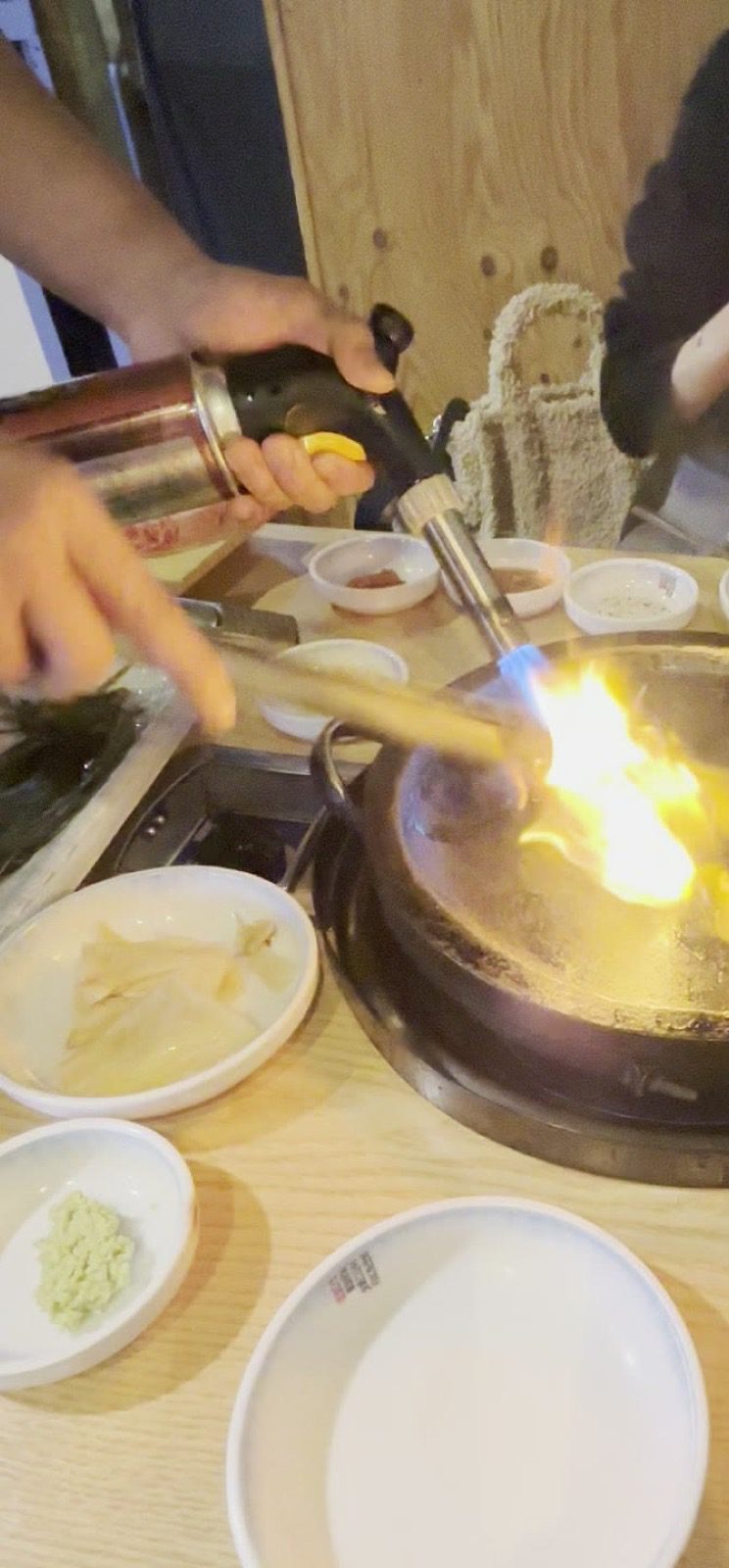 店員以噴槍在烤盤上進行火焰秀,火舌升起的瞬間
