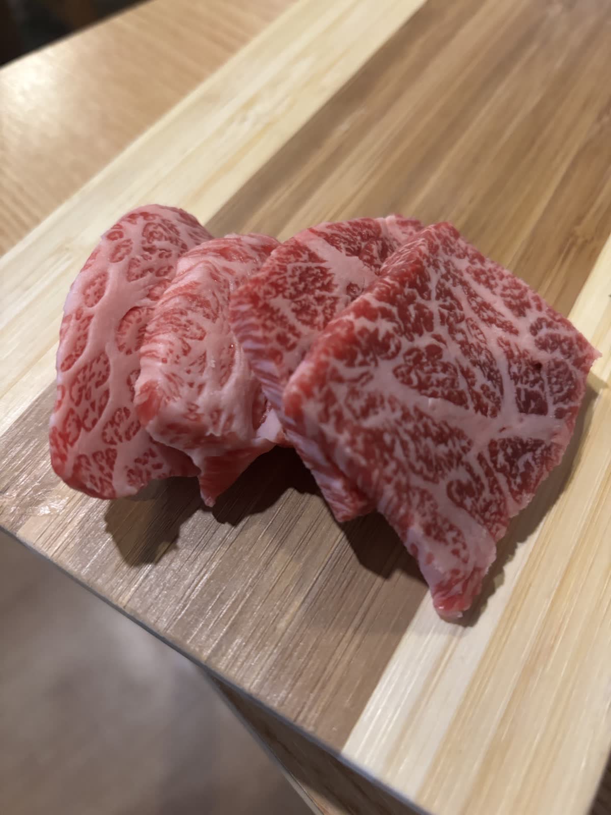 盤上厚切熟成韓牛生肉特寫,油花紋路清楚