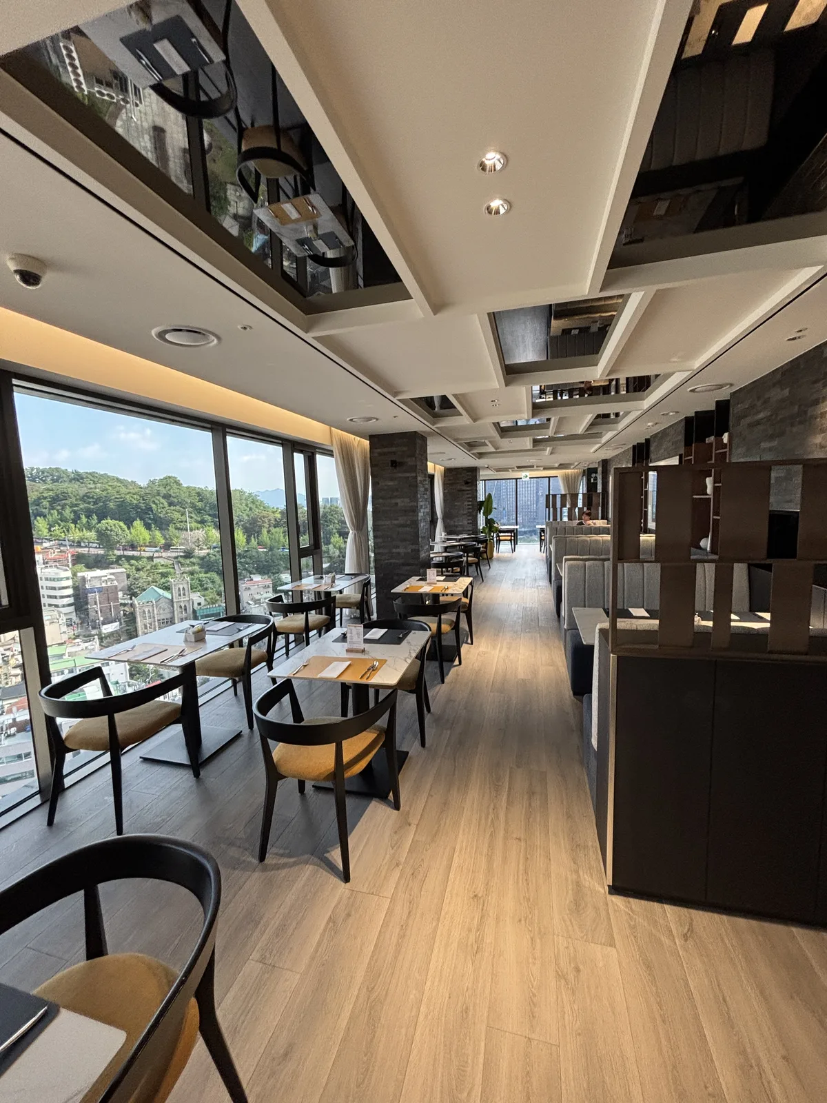 voco Seoul Myeongdong Club Lounge 落地窗座位與深色木質用餐空間