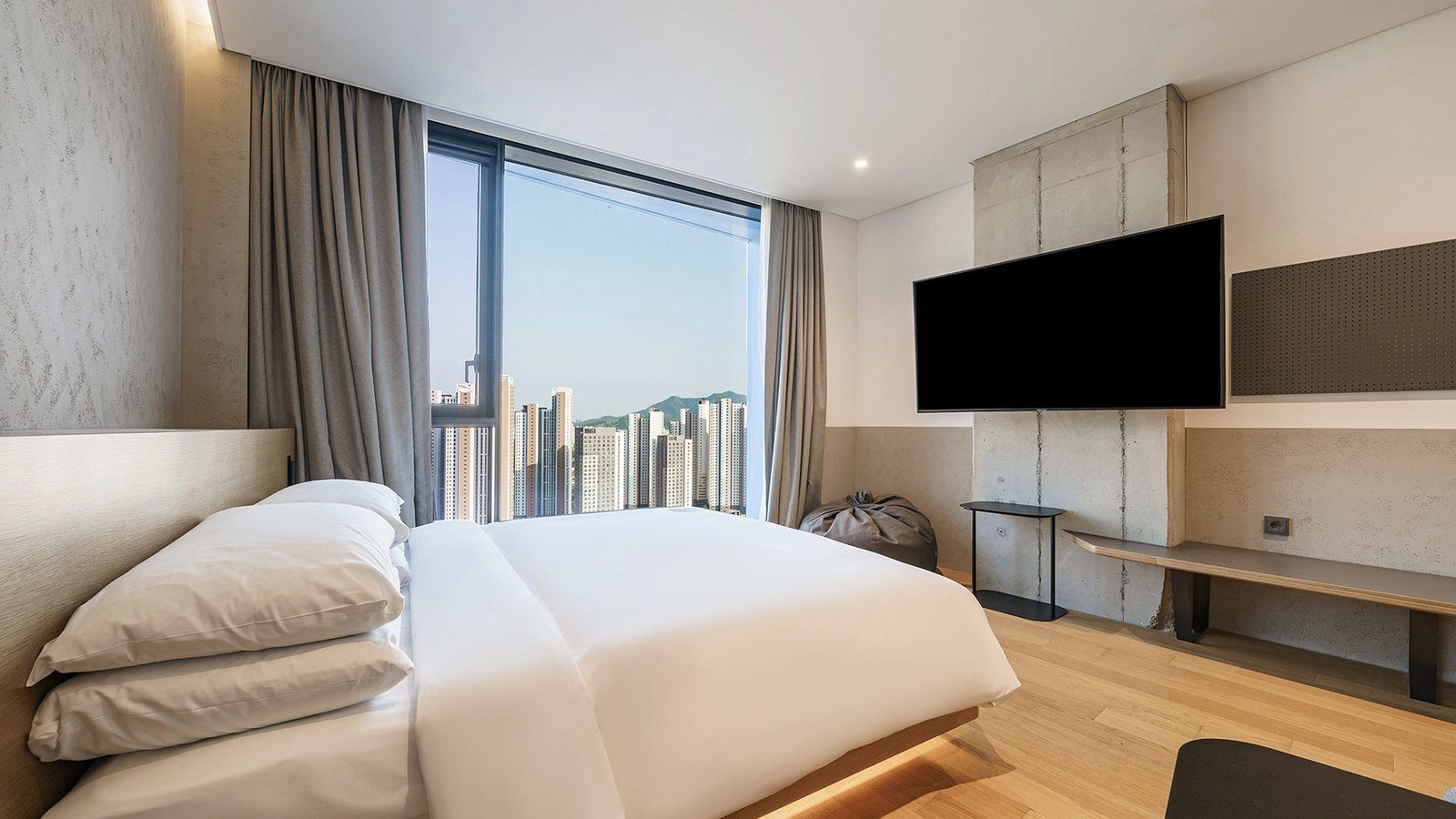 Standard Double 客房的大床與窗外高樓景觀