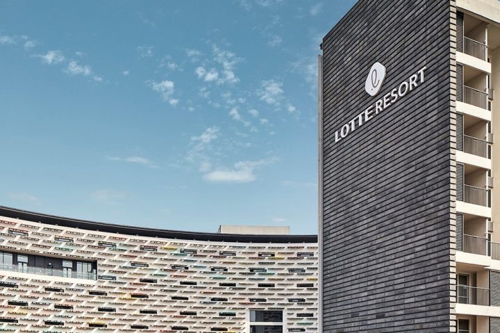 扶餘樂天度假村深灰色塔樓上的 LOTTE RESORT 標誌與彩色弧形外牆