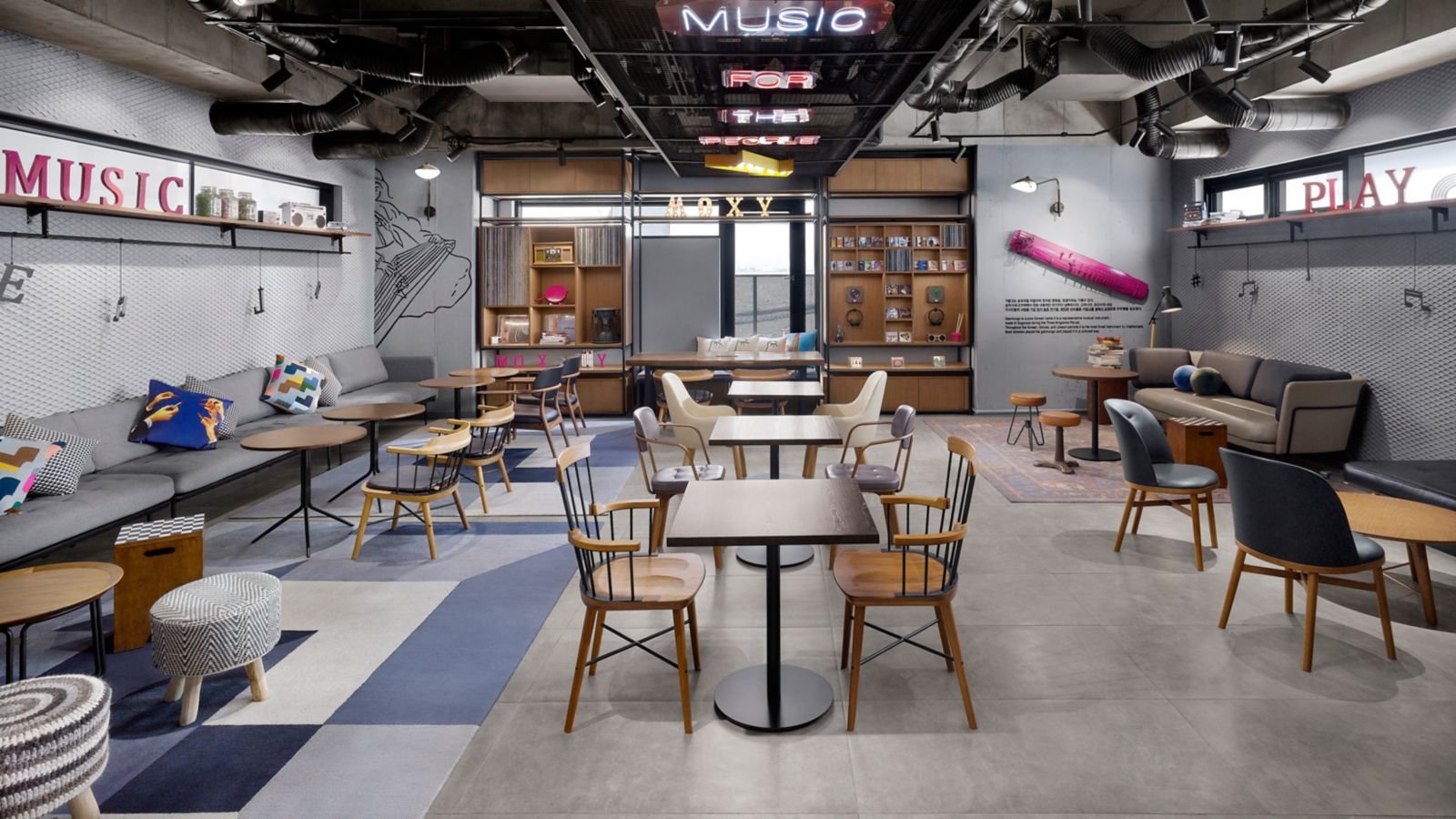 Moxy 共用空間的桌椅與工業風天花板