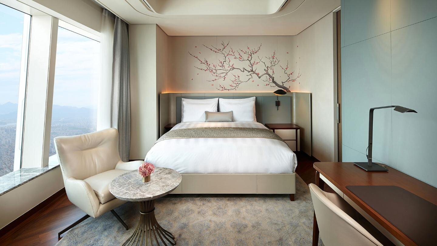 Grand Deluxe 客房的床鋪與高空窗景