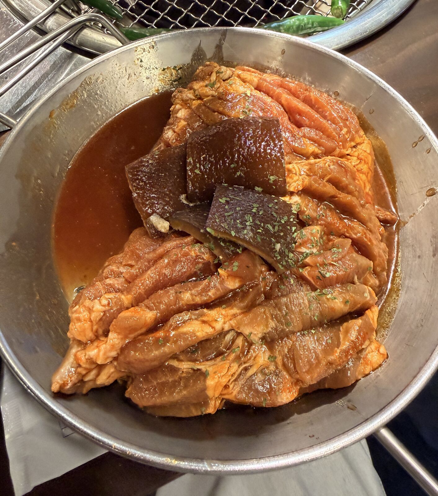 金屬盤裡的醃肉排與方形豬皮