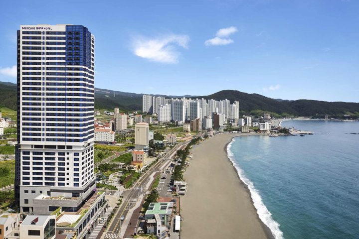 蔚山美居大使酒店的高樓外觀與旁邊的長海灘