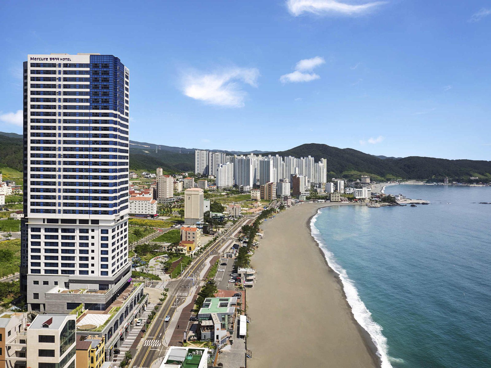 蔚山美居大使酒店的高樓外觀與旁邊的長海灘