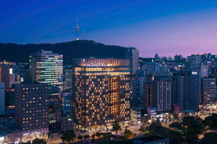 首爾東大門諾富特大使酒店的大樓夜間外觀與後方南山首爾塔