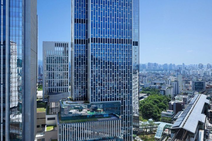 首爾 Eastpole 鉑爾曼大使酒店的玻璃帷幕大樓外觀與旁邊的地鐵高架站