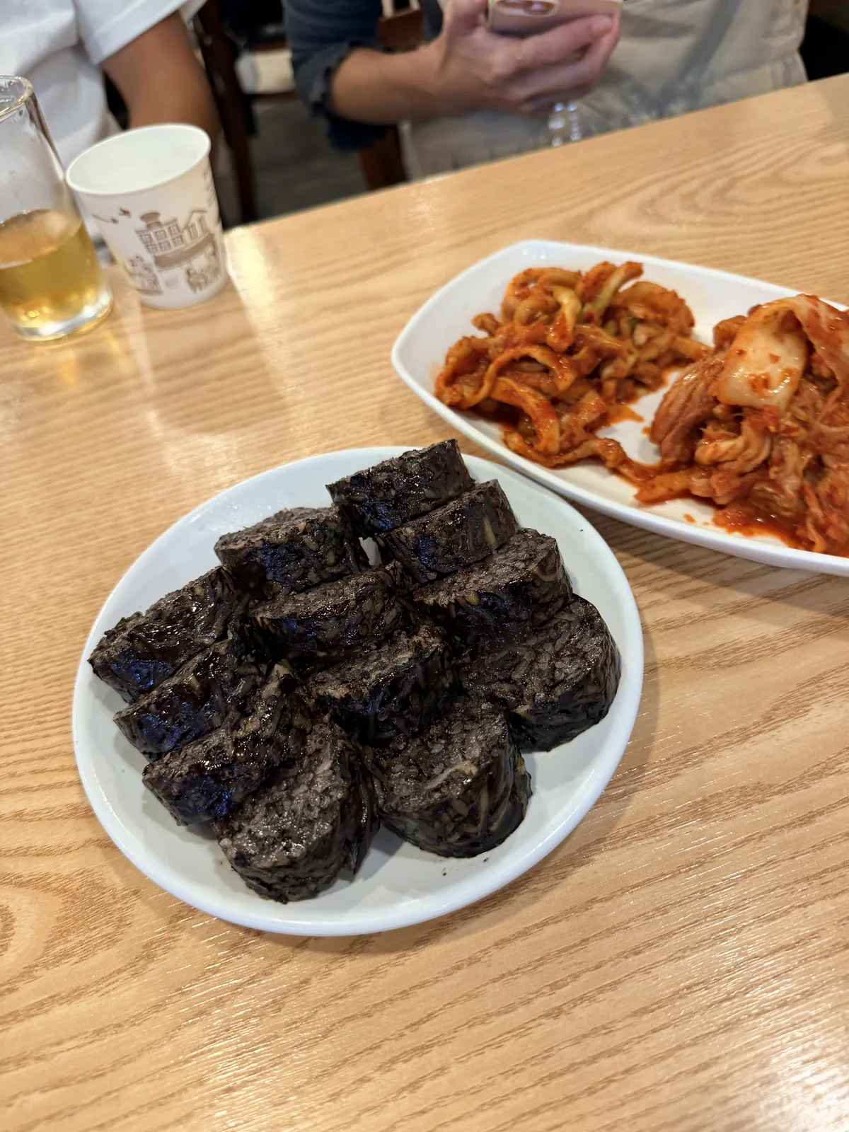 松亭三代國飯的北韓式糯米血腸特寫，旁邊是辣拌內臟
